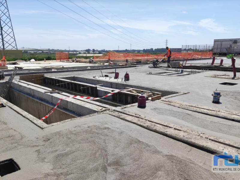 Imagen de construcción con trabajadores en un área de hormigón, mostrando la preparación para el emplazamiento.