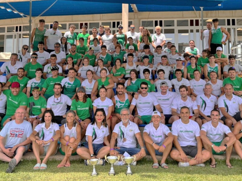 Equipo de fútbol celebrando con trofeos en un campo de juego.