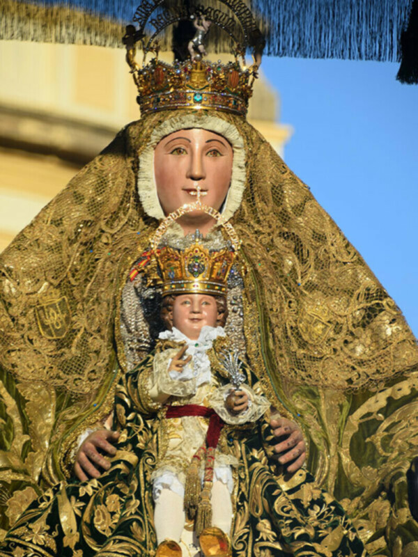 Imaginaria de la Virgen de la Esperanza de la Catedral de Málaga, España, con vestimentas doradas y un niño en sus brazos.