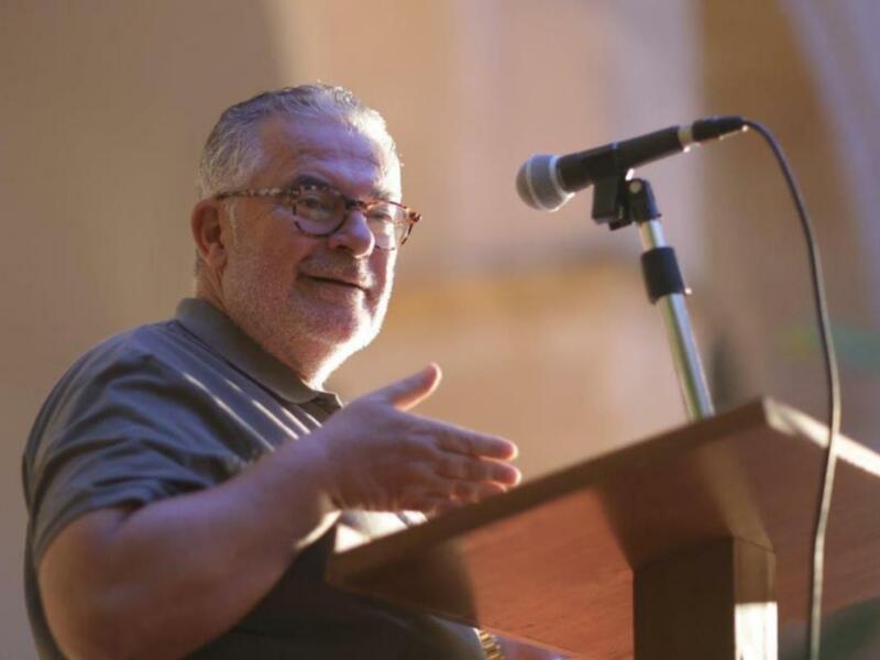 Hombre en una conferencia de negocios, hablando en un micrófono en un podio.