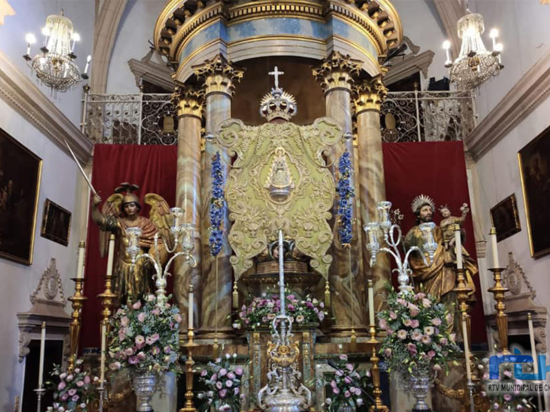 Altar ornado con estatuas y flores en una iglesia histórica.