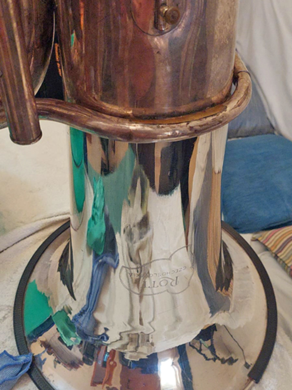 Un cuchillo de cocina de acero inoxidable con una funda de cuero negro. La funda tiene un diseño floral en relieve y está colocada sobre una toalla de color beige. La imagen se centra en el cuchillo, que es el principal objeto del foco.