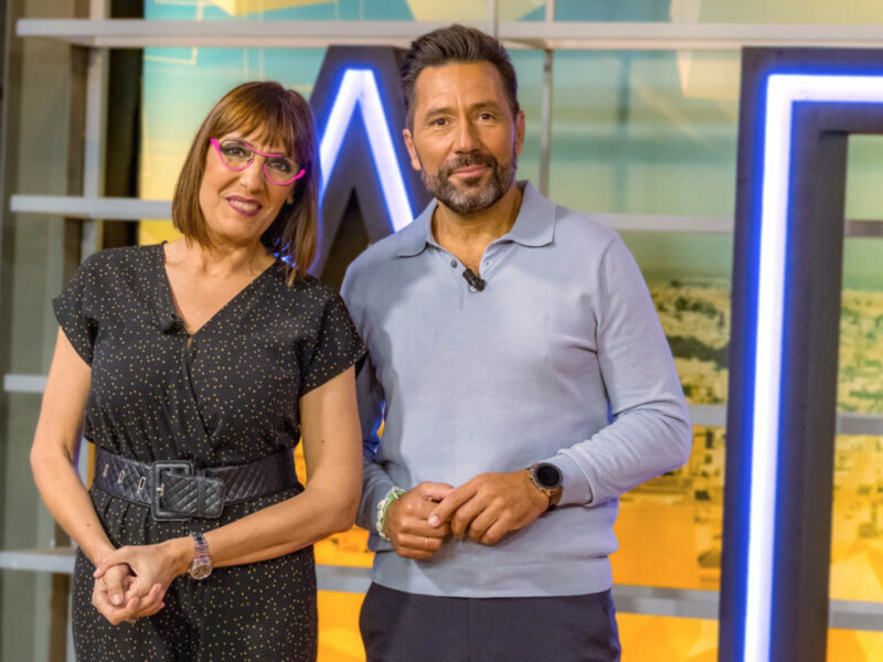Estos dos presentadores son los encargados de conducir este programa de televisión, con un entorno moderno y colorido en el fondo.