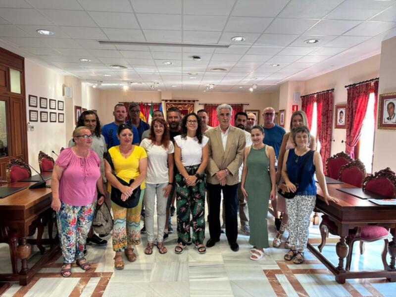Grupo de personas posando en una sala con muebles y cortinas.