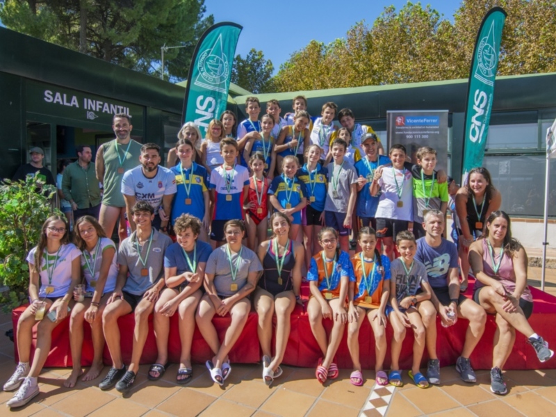 Equipo de atletas posando en el evento de la Fundación Vicente Ferrer, con medallas en la cintura y sonriendo para la foto.