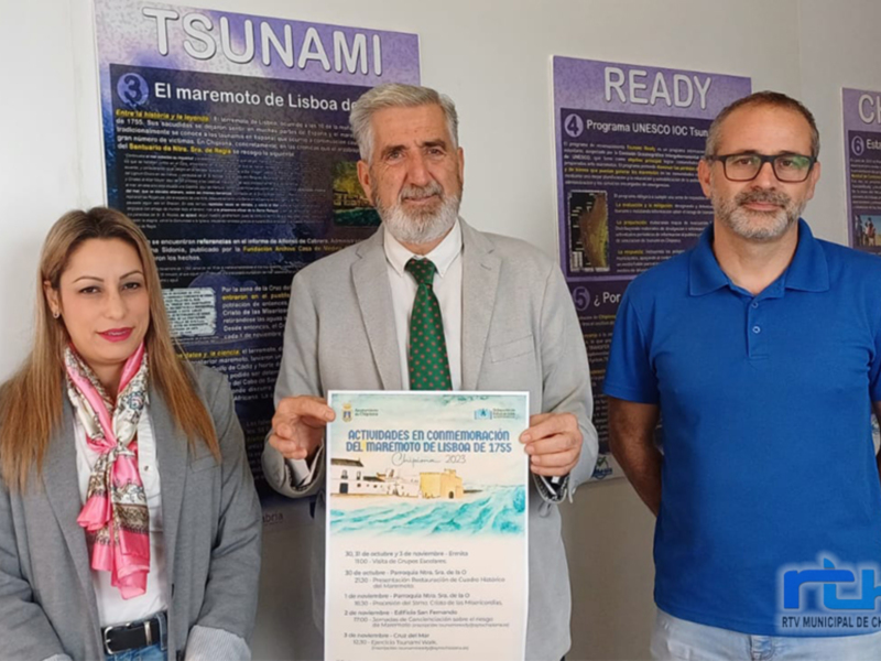 Tres personas posan con un folleto informativo sobre actividades en conmemoración del maremoto de Lisboa de 1755, en el contexto de un evento en Chipiona.
