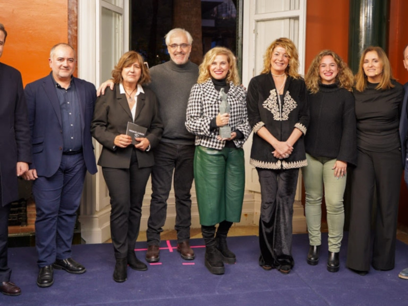 Una reunión formal de profesionales en un entorno elegante, posiblemente en una celebración o evento empresarial. Los individuos están vestidos formalmente, lo que sugiere un ambiente de respeto y profesionalismo.