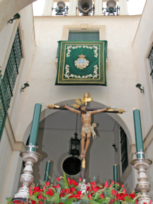 El crucificado de la Vera Cruz de  Alcalá del Río en unas andas, con la estampa inusual del traslado del Señor en posición vertical, tal y como sale e