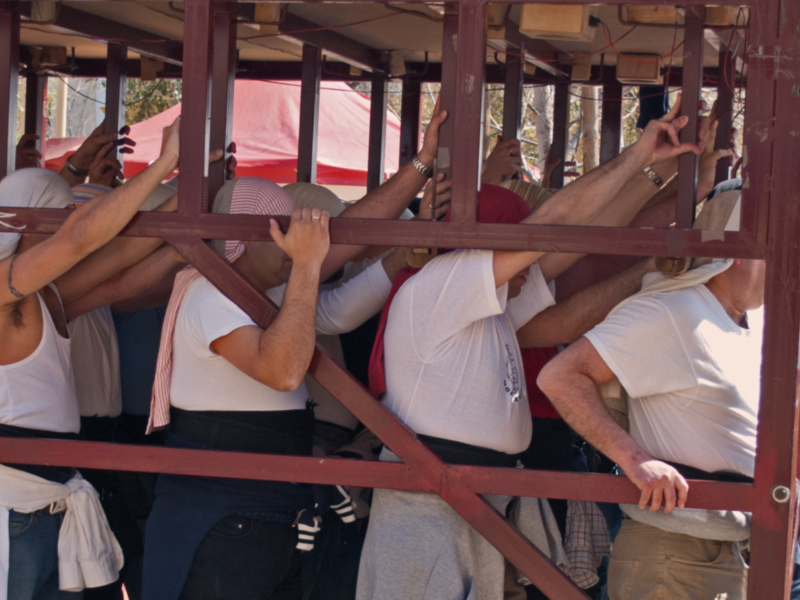 Un grupo de personas trabajando juntos para levantar una estructura de madera.