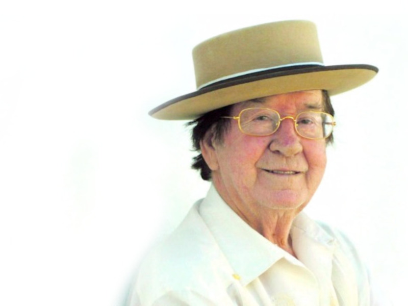 Un hombre con una camisa blanca y un sombrero beige.