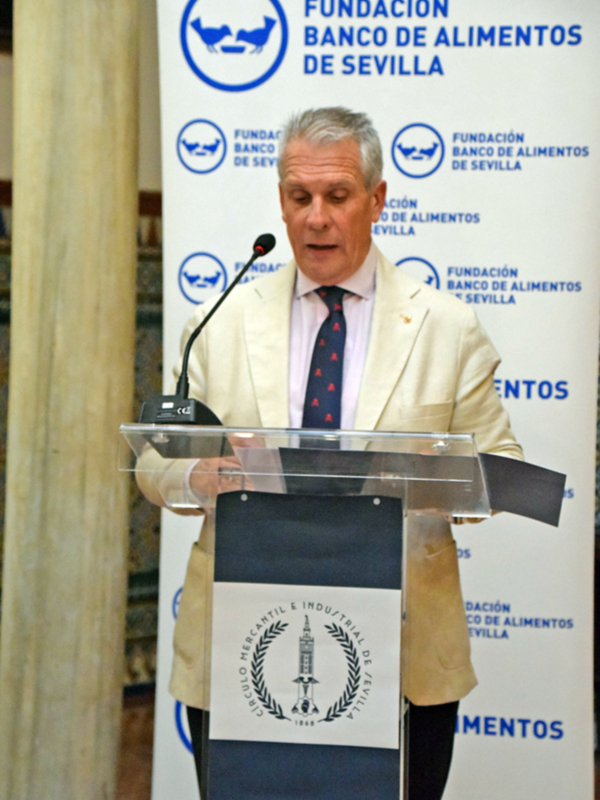 Un hombre habla en un podium con el logo de la Fundación Banco de Alimentos de Sevilla en el fondo.