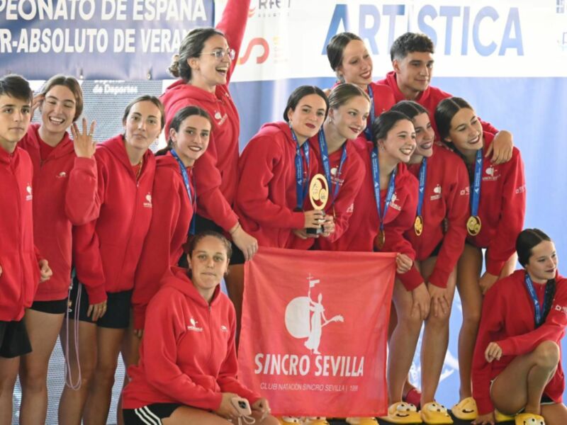 Equipo de sincronización celebrando el campeonato español, con medallas y bandera roja.