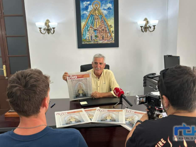 Entrevista en una oficina con una imagen religiosa en el fondo.