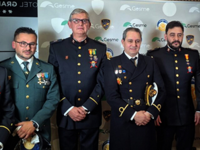 Grupo de oficiales militares en uniforme, posando en un evento formal. En el fondo, se puede ver el logo de Gesme.