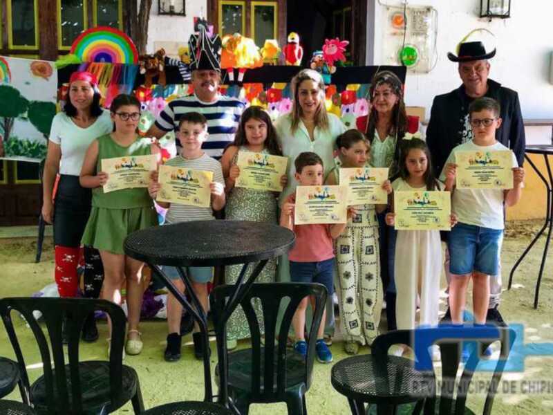 Niños y niñas recibiendo reconocimientos en una escuela, junto a adultos.