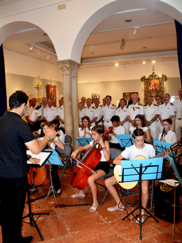 Orquesta infantil en un recital de música clásica en un salón histórico.