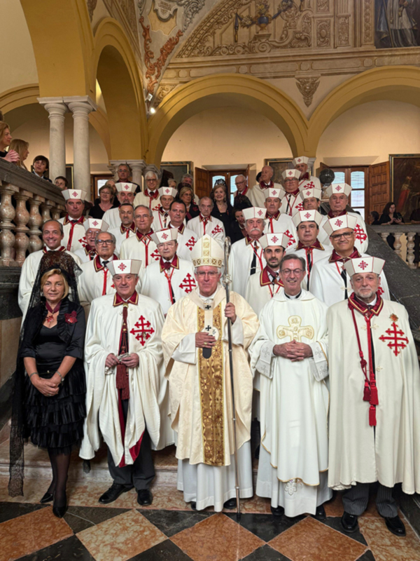 Una imagen de una celebración religiosa o ceremonial, con varias personas vestidas con vestimentas tradicionales y coronas, posiblemente en una iglesia o palacio histórico. La decoración del techo y la arquitectura sugieren un ambiente formal y festivo.