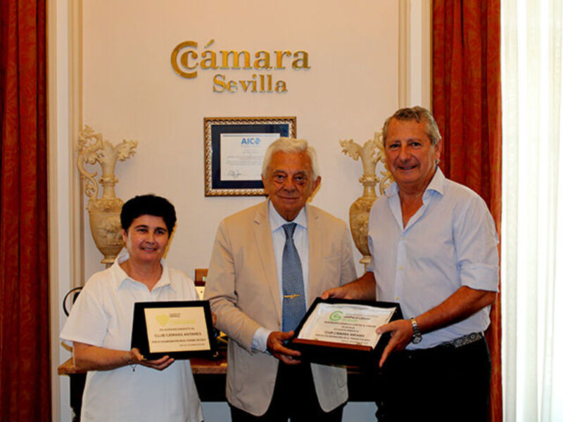 Tres personas posan con certificados en la Cámara de Comercio de Sevilla.