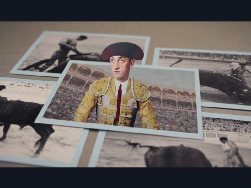 Un retrato de un torero en uniforme amarillo, rodeado por fotografías antiguas de corridas de toros y carreras de automóviles, en un fondo de madera.